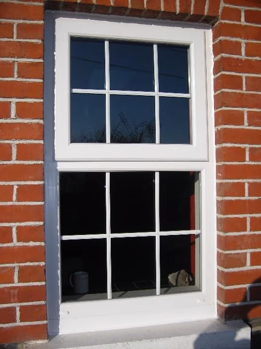 Dark-framed replacement sash window on a Victorian terrace