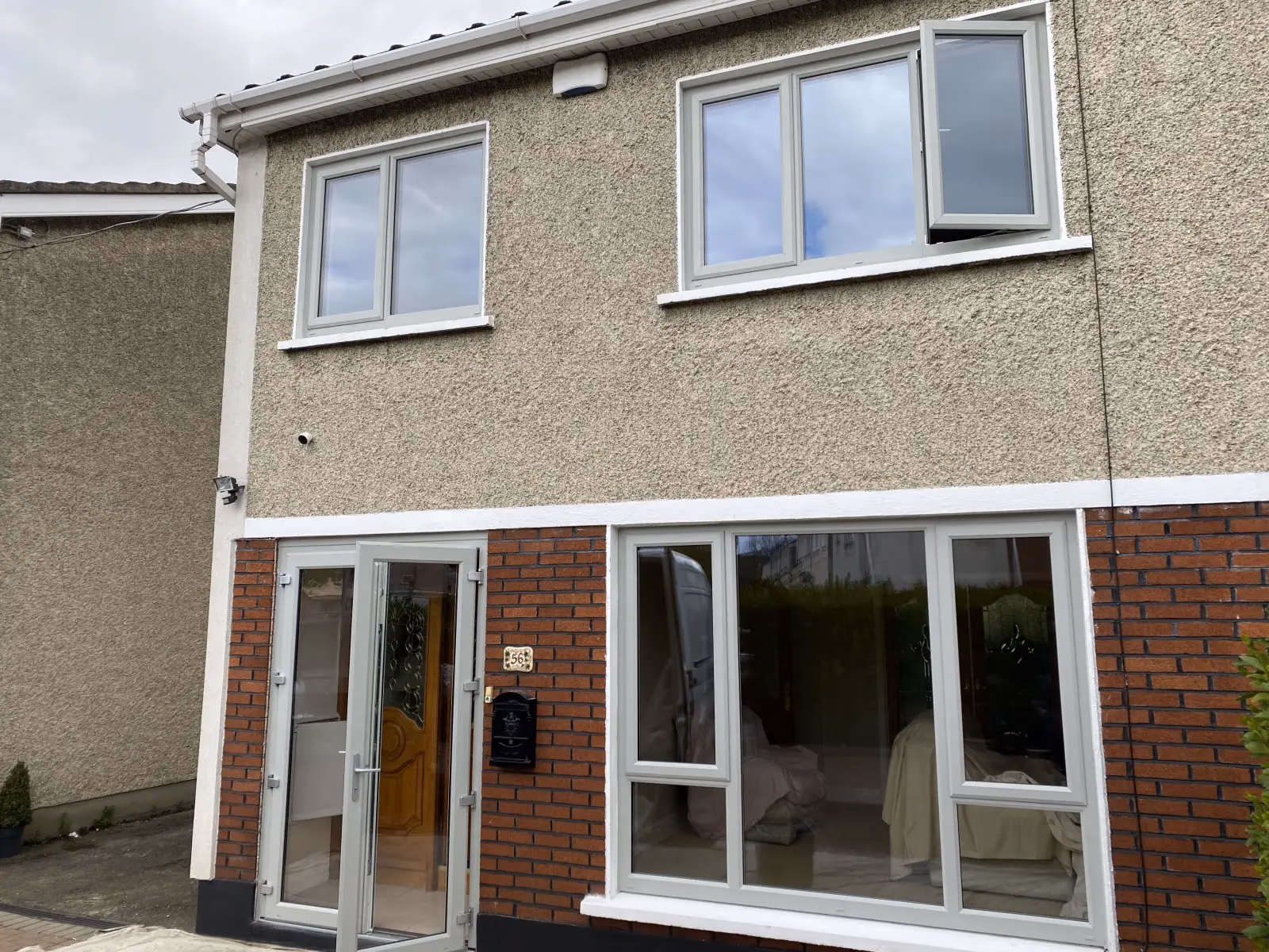 White uPVC French doors and casement windows on a pebble-dash semi