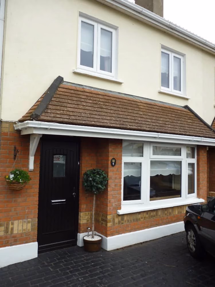 Cream uPVC bay and dormer windows on a 1930s brick semi