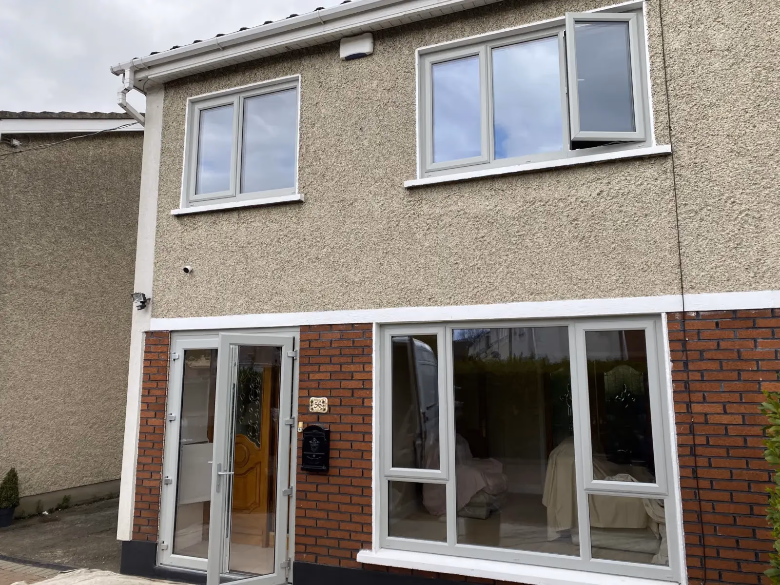 White uPVC French doors and windows on a pebble-dash semi