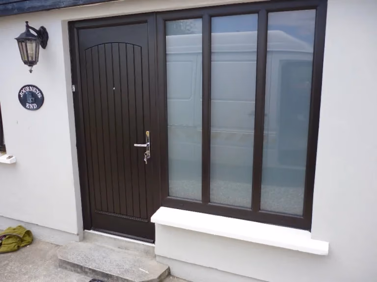Dark composite front door with full-height glazed side panels
